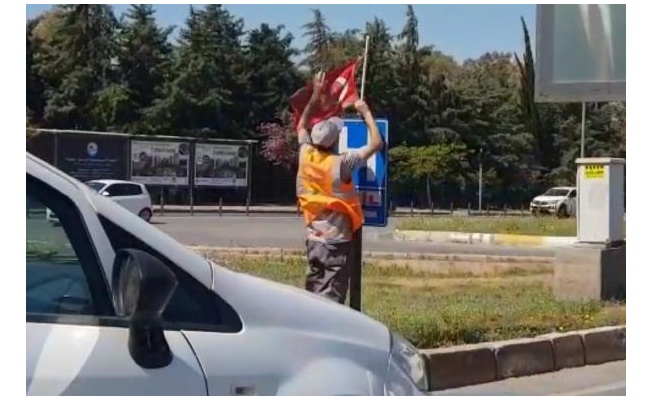 Yerde bulduğu Türk bayrağını temizleyip, tabelaya astı